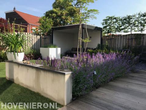 Moderne tuin met overkapping en witte bloempotten en plantenbakken 1