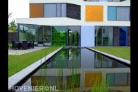 Strakke heldere vijver bij huis in moderne stijl