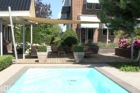 Zwembad met  vlonder en schaduwdoek