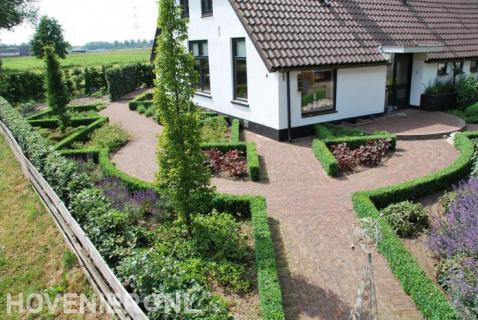 Klassieke tuin met buxushagen en bestrating van rode waaltjes 1