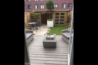 Vlonderterras met loungeset en houten overkapping met schuurtje 1