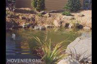Vijver met fontein en rotsen aan de oevers