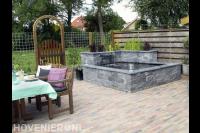 Vijver met watermuur van stenen in rotsmotief