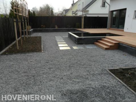 Tuin met verhoogde vlonder, vijver, leibomen en basalt grind