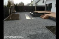 Tuin met verhoogde vlonder, vijver, leibomen en basalt grind