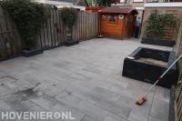 Tuinaanleg met keramische tegels en plantenbakken