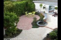 Tuinaanleg met sierbestrating in rode en gele tinten