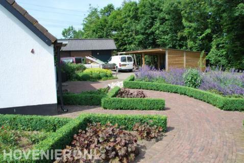 Klassieke tuin met buxushagen en bestrating van rode waaltjes 2