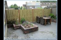 Achtertuin met houten schutting en verhoogde bloembak