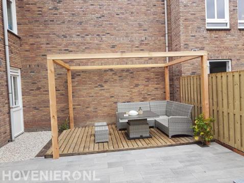 Houten pergola boven vlonder met tuinset