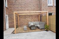 Houten pergola boven vlonder met tuinset