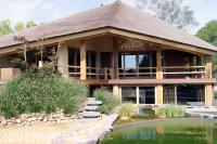 Zwemvijver en border met siergras en rotsblokken bij villa 1