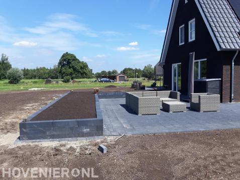 Aanleggen terras met betontegels en grote plantenbak