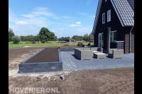 Aanleggen terras met betontegels en grote plantenbak