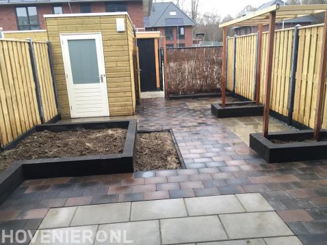 Tuinaanleg met bestrating, verhoogde borders, pergola en schutting