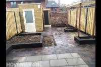 Tuinaanleg met bestrating, verhoogde borders, pergola en schutting