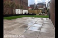 Grote achtertuin met bestrating en kunstgras
