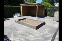 Tuinaanleg met bestrating, plantenbak en houten overkapping