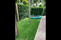 Kunstgras in tuin met speeltoestel en trampoline