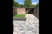Achtertuin aanleggen met bestrating, plantenbak en kunstgras