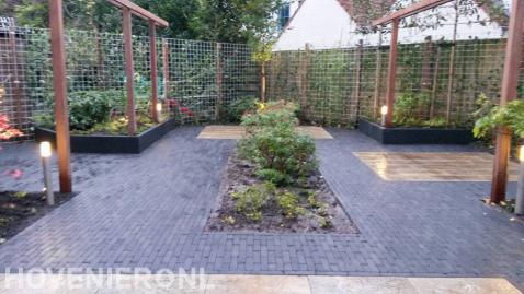 Tuin met bestrating, plantenbakken en houten pergola's