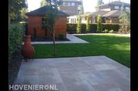 Open tuin met tuinhuisje en gazon