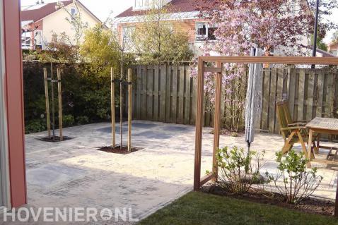 Nieuwe bestrating in achtertuin met pergola