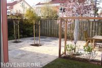 Nieuwe bestrating in achtertuin met pergola