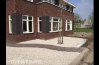 Onderhoudsarme voortuin met grind en tuinpad van klinkers