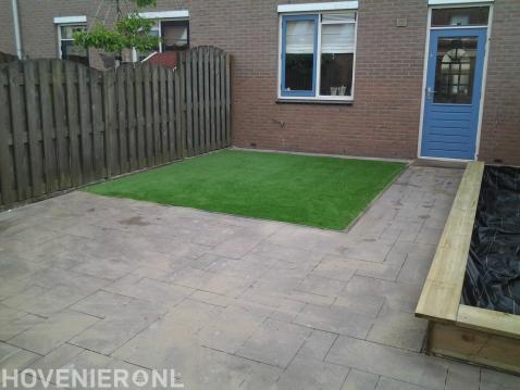 Kunstgras leggen en bestrating van tegels in wildverband