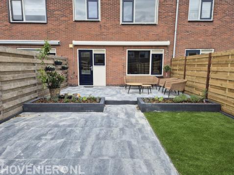 "Complete tuinrenovatie: borders, kunstgras en tegels"
