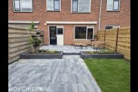 "Complete tuinrenovatie: borders, kunstgras en tegels"