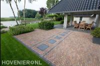 Tuin aan het water met gazon en overdekt terras