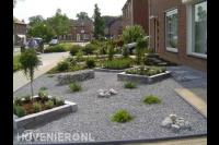 Onderhoudsarme voortuin met plantenbakken en split
