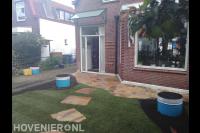 Gazon met stapstenen en flagstones in voortuin