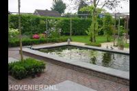 Tuin met vijver, pergola en gazon