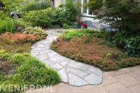 Pad van flagstones tussen kleurrijke borders