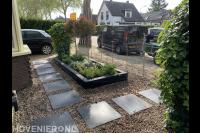 Voortuin met grind, siertegels en plantenbak