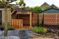 Tuin met vijver en kleine houten overkapping