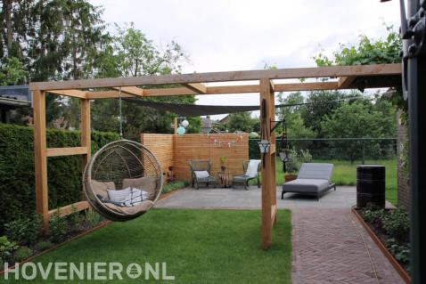 Robuuste houten pergola met schommelbank en schaduwdoek