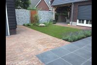 Tuinaanleg met sierbestrating, gazon van kunstgras en schanskorven 1