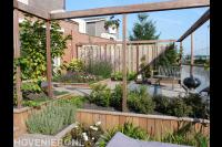 Tuinaanleg met houten pergola's en plantenbakken