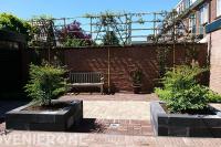 Tuin met plantenbakken van stapelblokken en leibomen 1