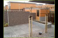 Onderhoudsarme achtertuin met grote tuintegels, split en schanskorf 1