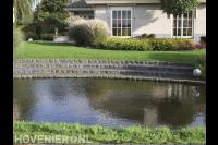 Stenen trap van gazon naar vijver