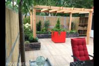 Onderhoudsvriendelijke tuin met houten pergola en rode plantenbakken 2
