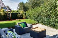 Terras van grote keramische tegels met loungeset