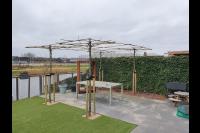 Achtertuin aan het water met pergola