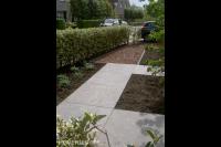 Looppad van grote tuintegels en boomschors