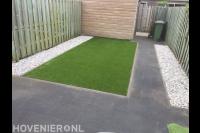 Onderhoudsvriendelijke achtertuin met bestrating, grind en kunstgras